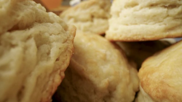Close up shot of a camera flying through a basket of beautiful fresh make biscuits