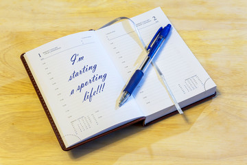 The diary is on the table. The diary is open on the first of January page. The page reads: "I'm starting a sporting life!!!".
