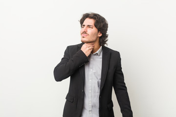 Young business man against a white background suffers pain in throat due a virus or infection.