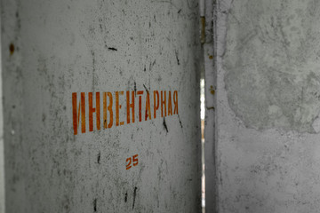 White door with red cyrillic inscription meaning "Inventory", or "Storage". Inside Chernobyl exclusion zone, town of Pripyat