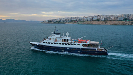 Fototapeta na wymiar Aerial drone photo of yacht cruising in Mediterranean open sea bay at sunset with beautiful colours