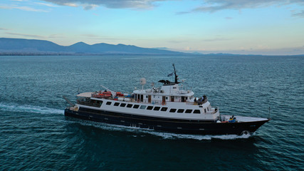Aerial drone photo of yacht cruising in Mediterranean open sea bay at sunset with beautiful colours