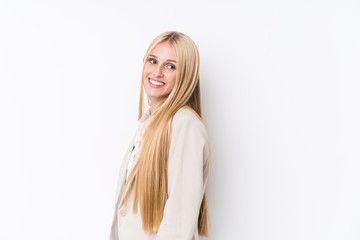 Naklejka premium Young business blonde woman on white background looks aside smiling, cheerful and pleasant.