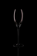 A glass of wine on a dark background in a counterlight.