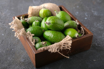 Harvest. Feijoa fruit in a wooden plate on a cutting kitchen board.
