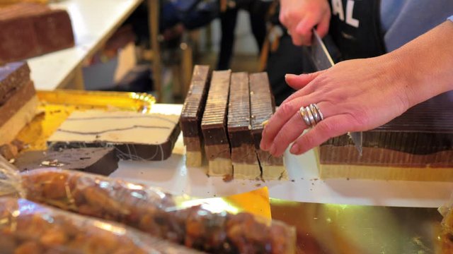Artesano cortando pastillas de turr&oacute;n de chocolate con cuchillo