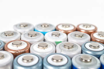 Obraz premium Energy abstract background of colorfu lithium rechargeablel batteries. Close up top view on rows of selection of Ni-MH AA batteries. Several batteries are next to each other.