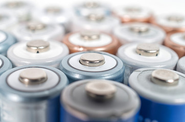 Energy abstract background of colorfu lithium rechargeablel batteries. Close up top view on rows of selection of Ni-MH AA batteries. Several batteries are next to each other.