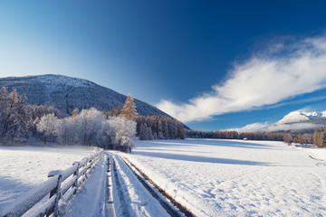 winter wonderland road in the mountains with snow and blue sky