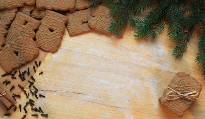Gringerbread cookies and christmas spices flatlay on a wooden surface.