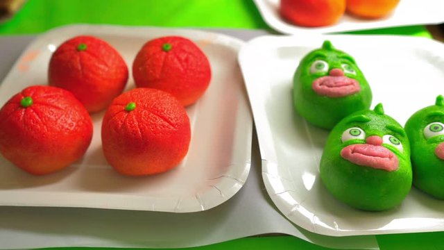 dos platos con mazap&aacute;n decorado con forma de cara verde y naranjas