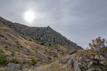 Mountain landscape. Cloudy day, view of the rocks from below. Autumn.