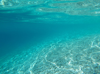Fototapeta na wymiar White stones under turquoise water in the sea.