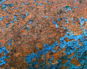 Old painted granite stone rock background. Blue, yellow, brown, orange.