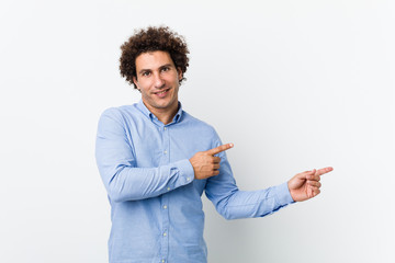 Young curly mature man wearing an elegant shirt excited pointing with forefingers away.