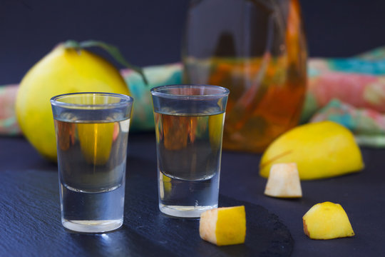 Quince alcoholic drink. Quince Brandy and fresh quinces on dark background. Serebian traditional dring, rakija or rakia.