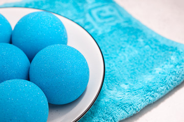 Blue bath bombs with towel on white tabletop