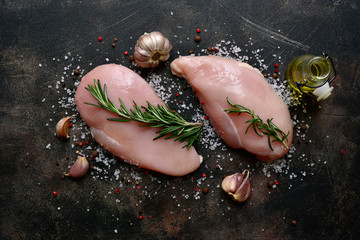 Raw organic chicken fillet with rosemary, salt and pepper. Top view with copy space.