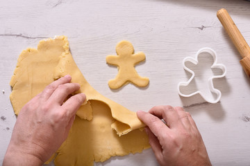 Christmas and New Year celebration traditions. Family home bakery, cooking traditional festive sweets. Woman cutting cookies of raw gingerbread dough