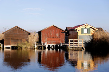 Neusiedler See, Lake Neusiedl. Bay with wooden pier and wooden cottage. Rust, Burgenland, Austria. Wooden houses in the center of the reeds near the lake.