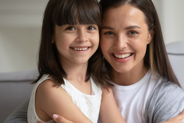 Closeup portrait of beautiful brown-haired mother and little daughter