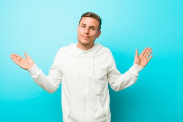 Fototapeta premium Young caucasian sport man doubting and shrugging shoulders in questioning gesture.