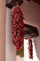 Dried chili peppers hanging outside on a building. Santa Fe. New Mexico. USA