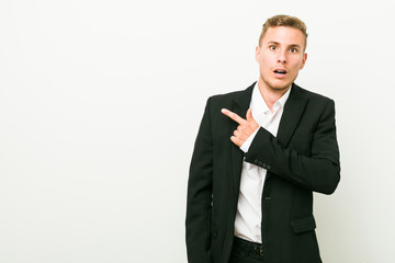Young caucasian business man pointing to the side