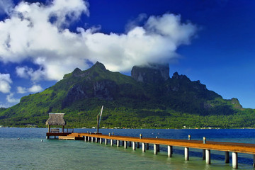 Pacific Island of Bora Bora with boardwalk and otemanu mountainm peak.