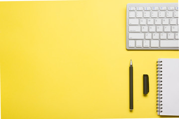 Yellow desk office with laptop, smartphone and other work supplies with cup of coffee. Top view...