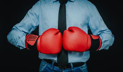A man, a businessman wearing a shirt, tie is wearing boxing gloves. The concept of fighting in the...