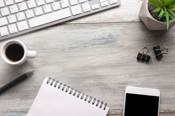 White desk office with laptop, smartphone and other work supplies with cup of coffee. Top view with...