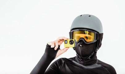 An athlete wearing a sweatshirt and helmet is recording sports exploits with a cam on white. The...