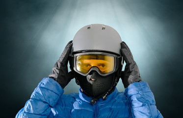 Skier wearing a ski helmet, google, gloves and a winter jacket. Concept of skiing, snowboarding. Winter sports.