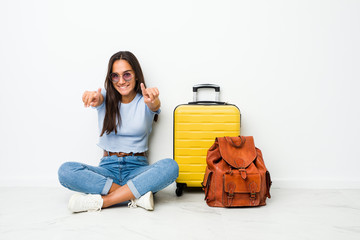 Young mixed race indian woman ready to go to travel cheerful smiles pointing to front.