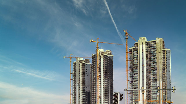 Generic two buildings under construction  with modern high rise towers building with tower cranes and unfinished exteriors