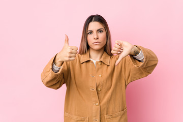 Young caucasian woman isolated showing thumbs up and thumbs down, difficult choose concept