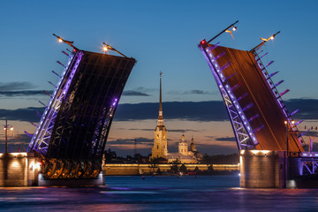 Fototapeta na wymiar Double-leaf bascule bridge (Palace Bridge) and the Peter and Paul fortress (Saint Petersburg, Russia). (Translation of Russian text on flags - 'Welcome')