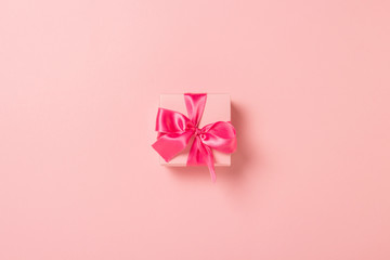 Pink gift box with pink ribbon on a pink background. Wedding concept, Valentine's Day, a gift for a loved one. Banner. Flat lay, top view