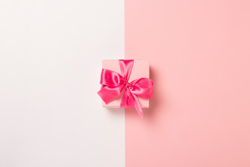 Pink gift box with pink ribbon on a pink and white background. Wedding concept, Valentine's Day, a gift for a loved one. Banner. Flat lay, top view
