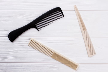 Set of hair combs on wooden background. Three plastic hair brushes and copy space.