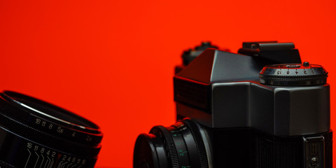Camera, lens under the light of a red lamp.