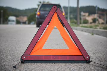 Accident or crash with two automobile. Road warning triangle sign in focus