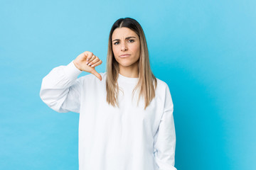 Young caucasian woman isolated showing a dislike gesture, thumbs down. Disagreement concept.