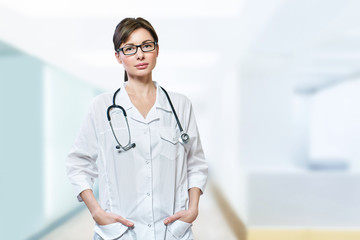 Portrait of serious doctor with stethoscope looking at camera.Medical physician doctor woman over blue clinic background