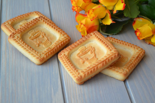 style lyfe concept with vintage cookies and yellow rose on blue wooden background