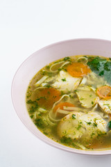 Classic chicken noodle soup with carrot and parsley isolated on white