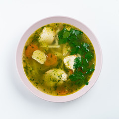 Classic chicken noodle soup with carrot and parsley isolated on white