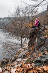 Girls sitting on the edge of autumn forest footpath. Orange leaves grabbing around. Nature Trail Svatojanske proudy. Slapy, Czech Republic. 