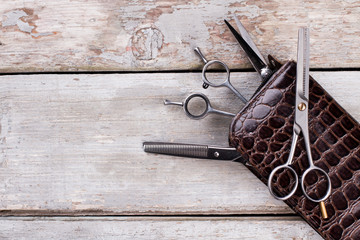 Professional hairdresser scissors on wooden background. Stylish barber scissors and copy space. Tool for cutting hair.